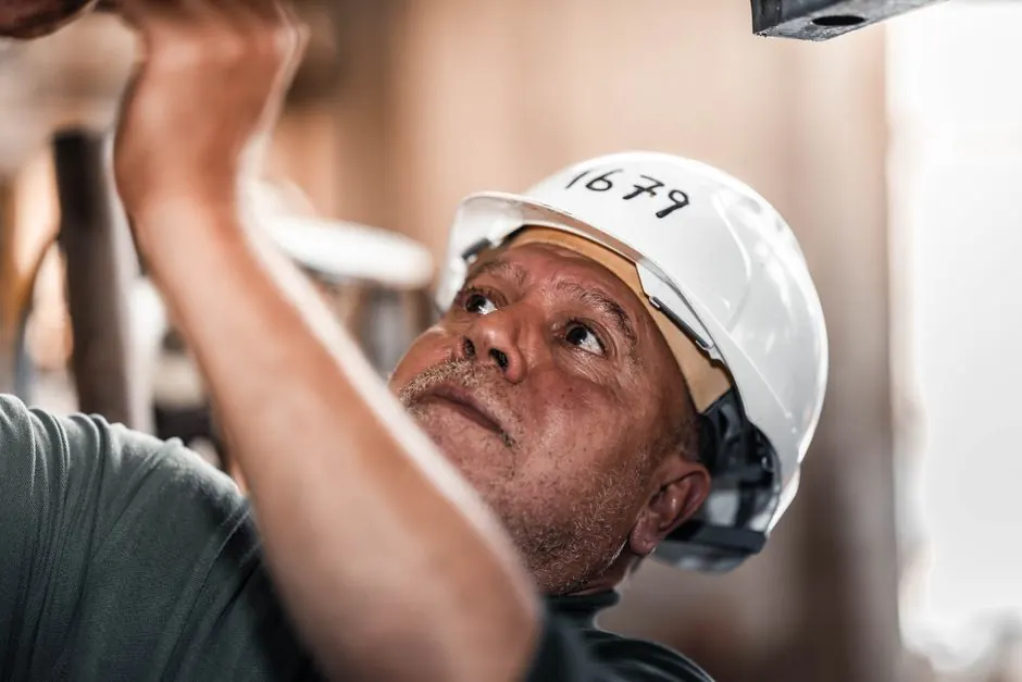 Construction worker in Libya concentrating on a task while wearing a safety helmet.